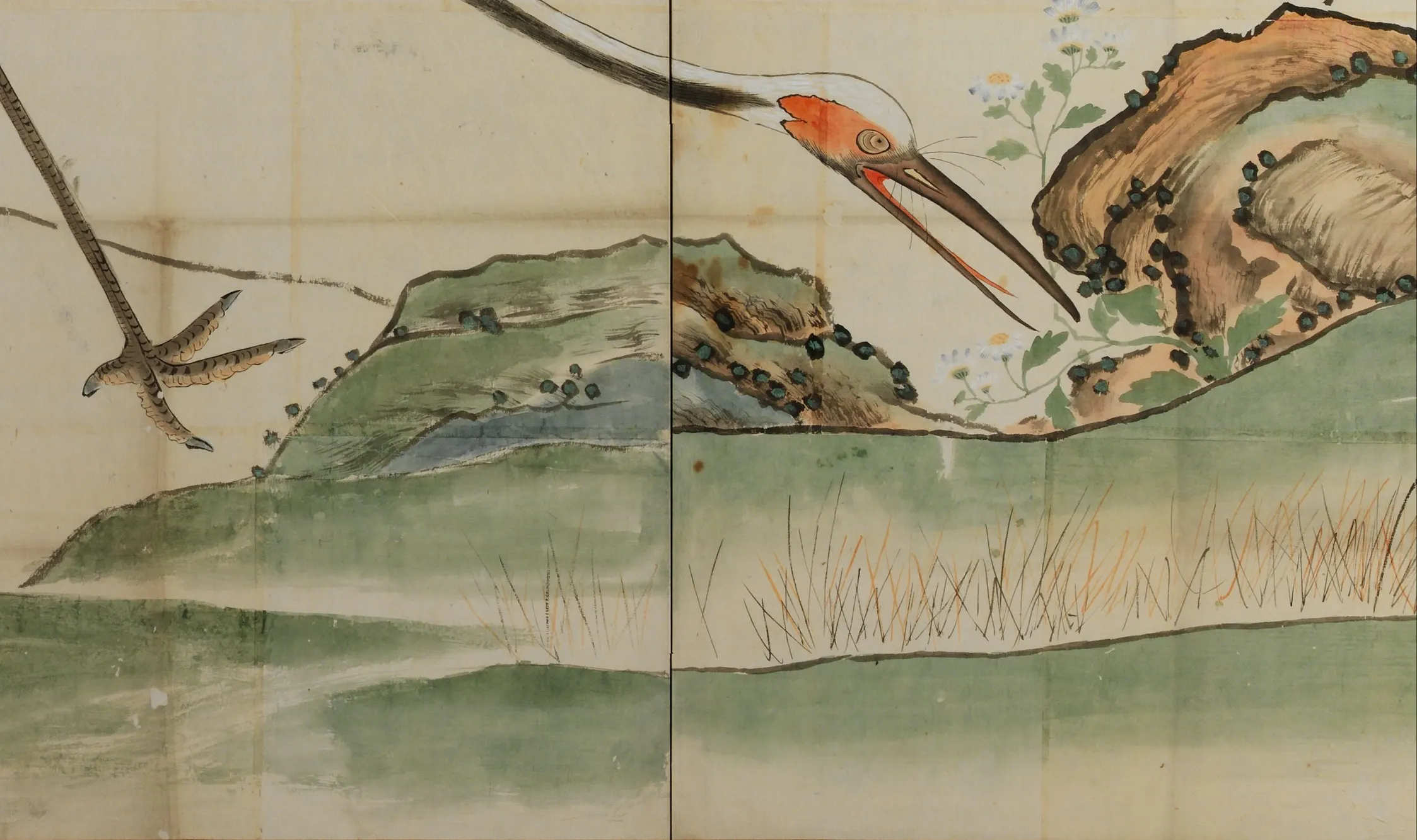 Detail of Cranes, Pines, and Bamboo in the Metropolitan Museum: each green mound has a second colour dropped into it while the first was still wet, and the two settled into blotches with a hard darker rim where the pool stopped. Directly below, the reeds are drawn one line at a time in black and orange. Two opposite ways of making a mark, sitting one above the other on the same bank.