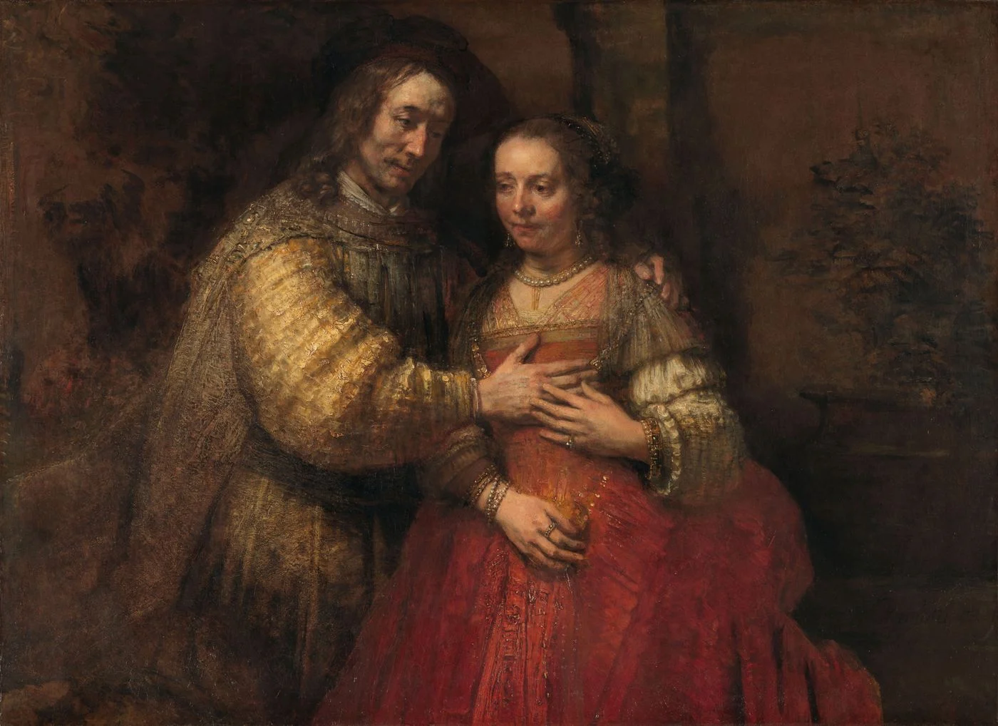 The Jewish Bride, painted in the last years, a canvas one hundred and twenty one by one hundred and sixty six centimetres. Almost all of it is held quiet, which is what lets the one loaded passage, the gold sleeve, carry the whole picture.
