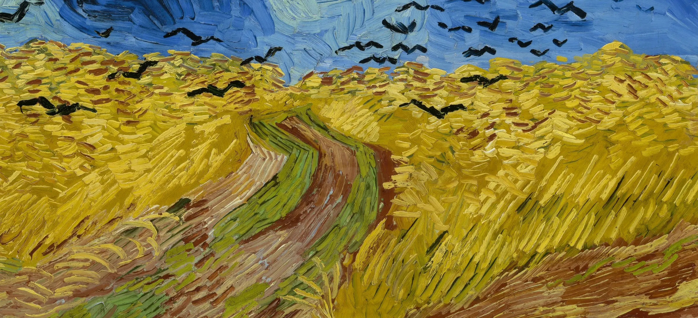 Detail of Wheatfield with Crows, painted at Auvers in the last summer: the corn is laid in short flat blocks lying the way cut corn lies, the track is dragged in long strokes running away from the viewer, and the sky is scrubbed across in bands. No edge is blended anywhere in it, so the direction of each mark is the only thing telling you which way the ground turns.