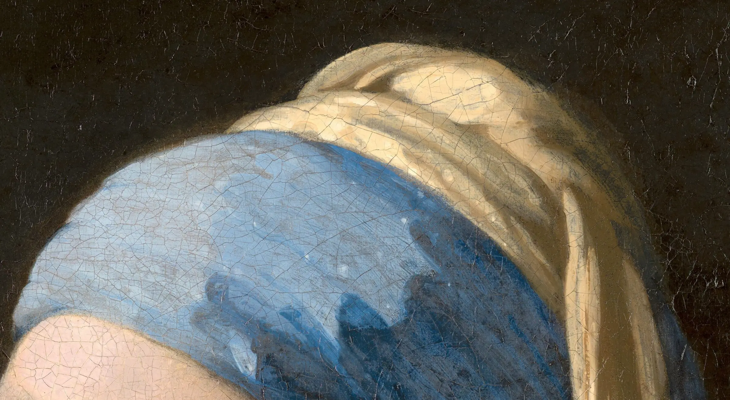 Detail of the headscarf in Girl with a Pearl Earring: the blue is natural ultramarine, ground from lapis lazuli brought out of what is now Afghanistan, and in the seventeenth century it cost more than gold. He did not keep it for the blue cloth. The 2018 examination found it in the scarf and in the jacket, and across his other pictures it turns up mixed into shadows and into whites where nothing blue is named.