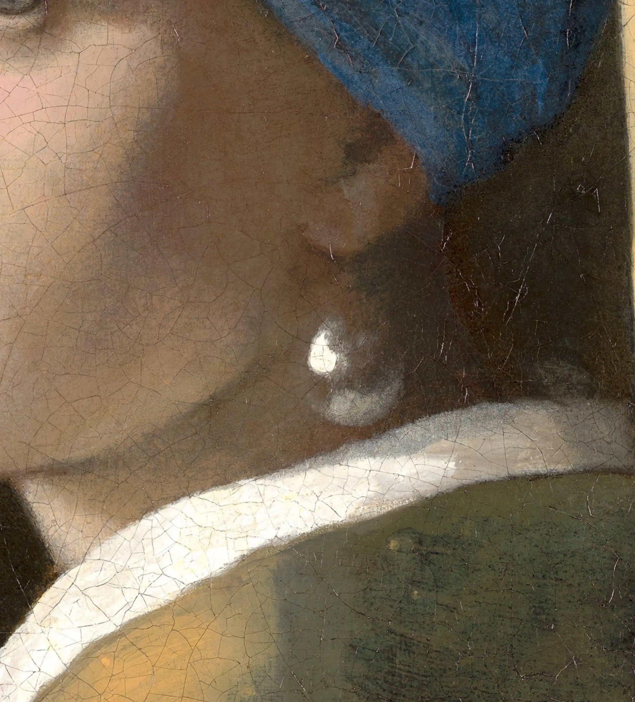 Detail of Girl with a Pearl Earring at the ear: the pearl is two marks of white, a thicker one on the upper left and a soft one low down where the white collar throws light back up into it. There is no hook and no drawn outline, and the shadow under the jaw runs straight through where the top of the pearl should be.